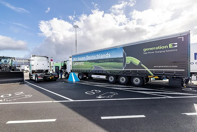 generation E Ladepark Kiel 5 Elektro-Lkw mit Werbeauflieger von Generation E auf einem Ladepark für elektrische Nutzfahrzeuge.