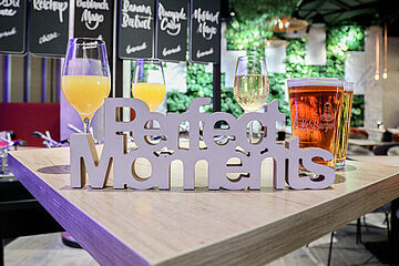"Perfect Moments"-Schriftzug auf einem Restauranttisch