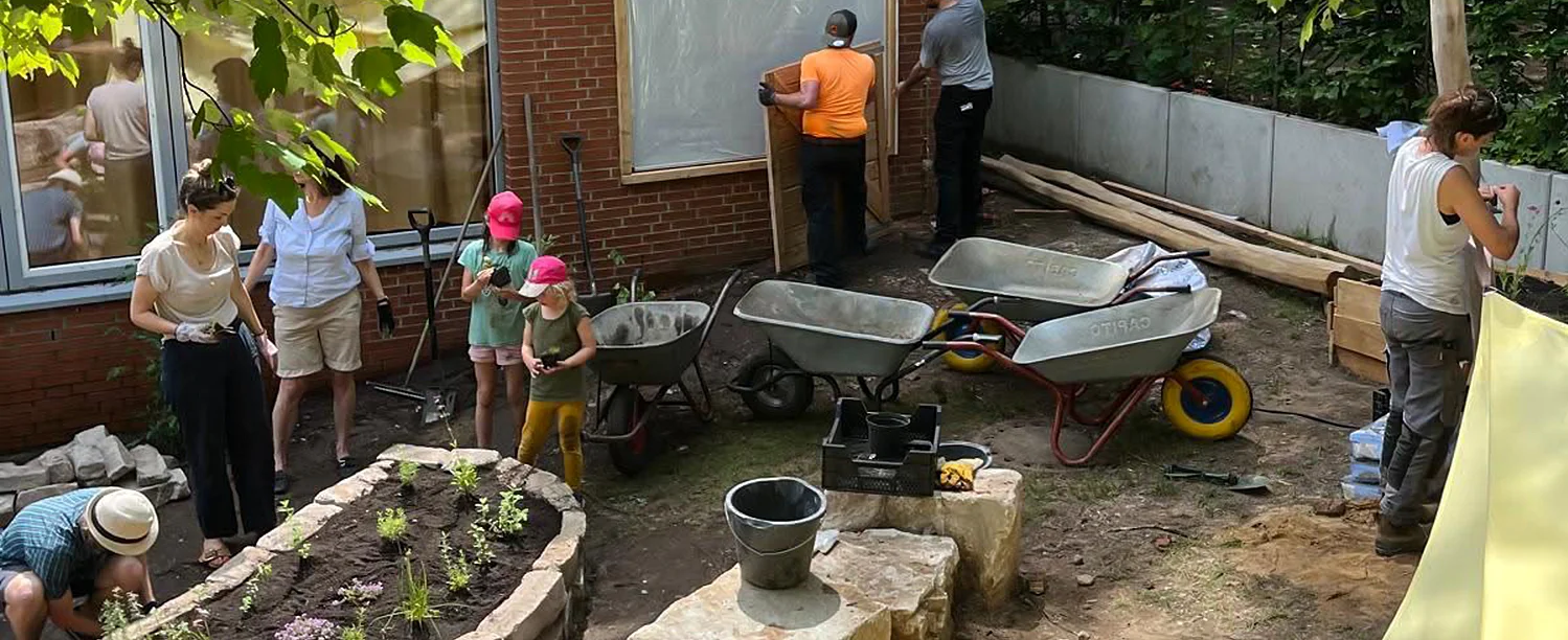 Eltern und Kinder beim bepfanzen eines Schulhofes 