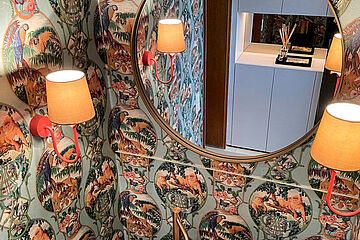 Badezimmer mit tapezierter Wand und Spiegel