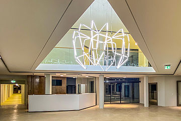 Eingangsbereich einer medizinischen Einrichtung mit einer Lichtskulptur in Form eines Zahns