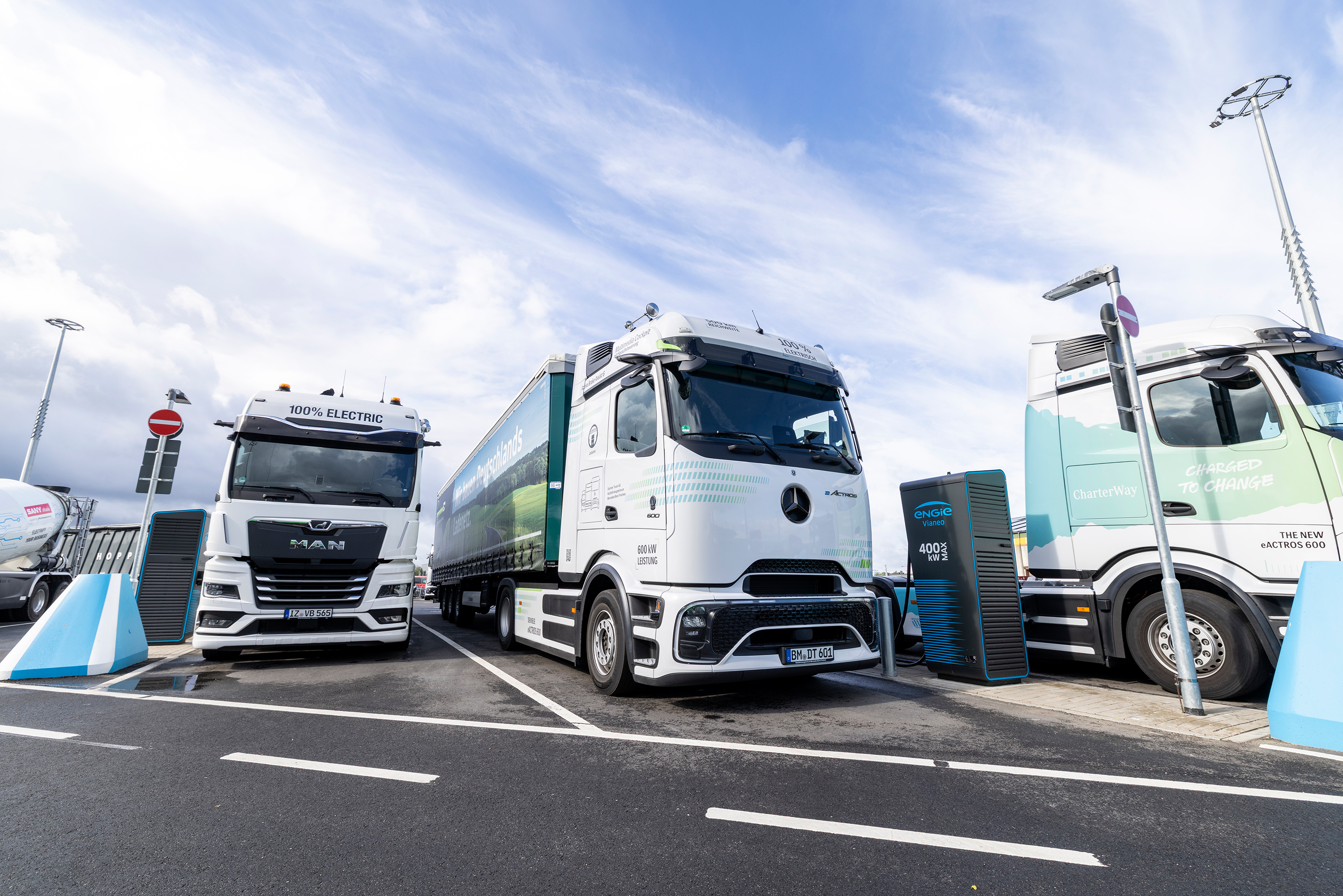 generation E Ladepark Kiel Mehrere elektrische Lkw stehen an einem Schnellladepark mit Hochleistungsladesäulen.